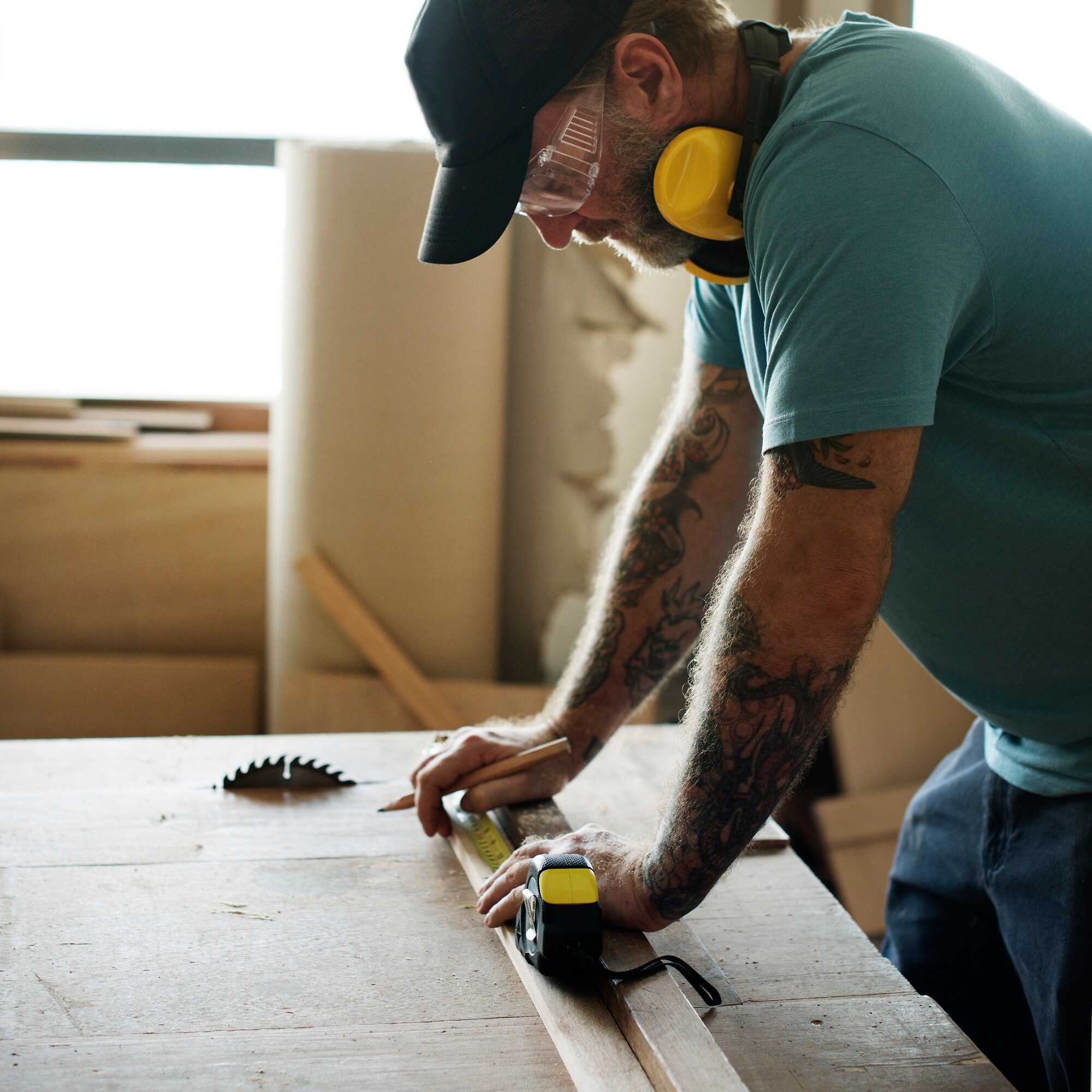 Timmerman meet een houten plank op met een rolmaat